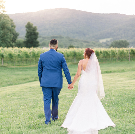 dawn rich wedding couple holding hands in field with mountain behind dawn rich wedding couple holding hands in field with mountain behind