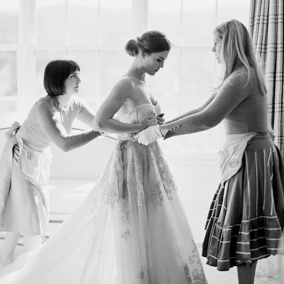 women helping bride get dressed women helping bride get dressed