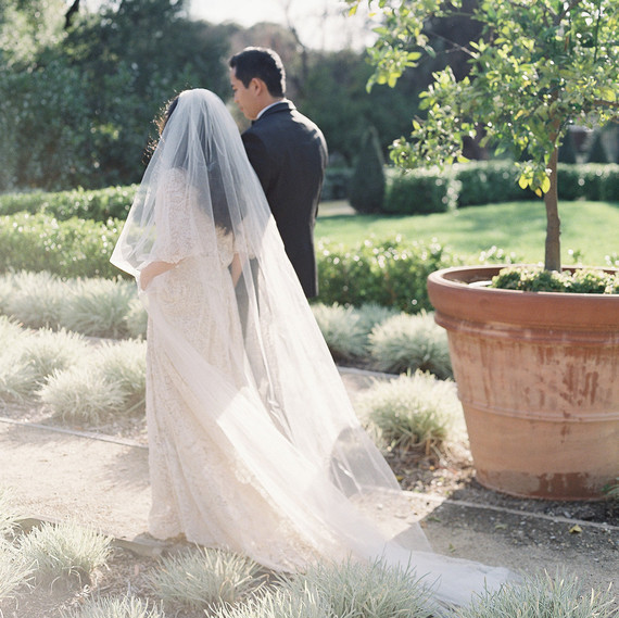 emme daji wedding couple walking through garden emme daji wedding couple walking through garden