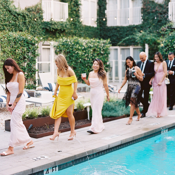 guests walk along pool side cocktail hour guests walk along pool side cocktail hour