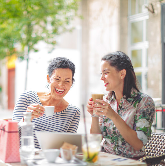 Mother-in-Law and Daughter Drinking Coffee and Laughing Mother-in-Law and Daughter Drinking Coffee and Laughing
