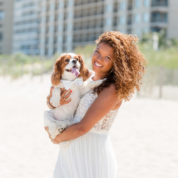 woman holding dog with white bow tie woman holding dog with white bow tie