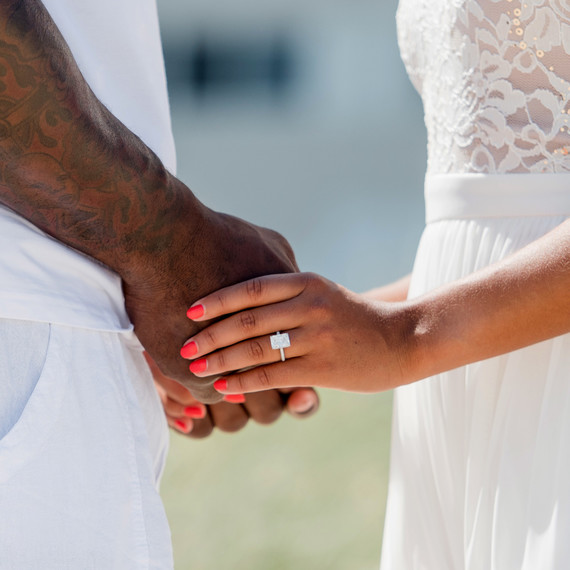 couple holding hands displaying engagement ring couple holding hands displaying engagement ring