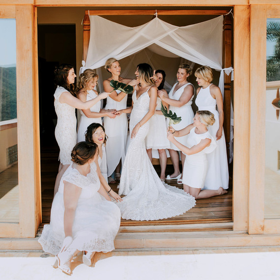 bride surrounded by female friends and family wearing white dresses bride surrounded by female friends and family wearing white dresses