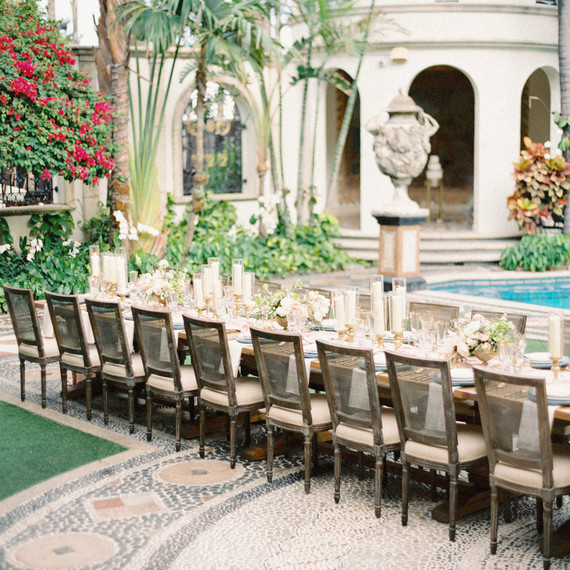 single long wedding reception table outside mansion next to pool area single long wedding reception table outside mansion next to pool area