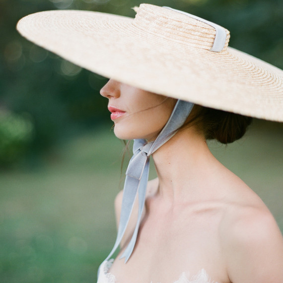 bride wearing large hat with blue ribbon bride wearing large hat with blue ribbon