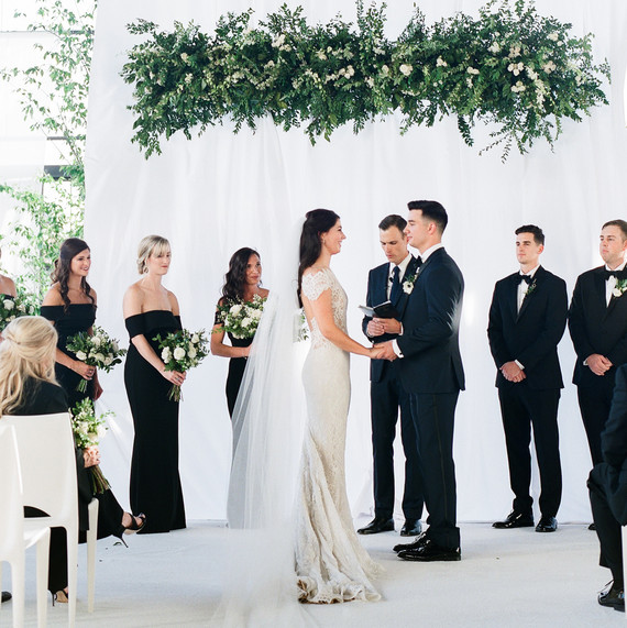 couple at religious wedding ceremony with greenery overhead couple at religious wedding ceremony with greenery overhead