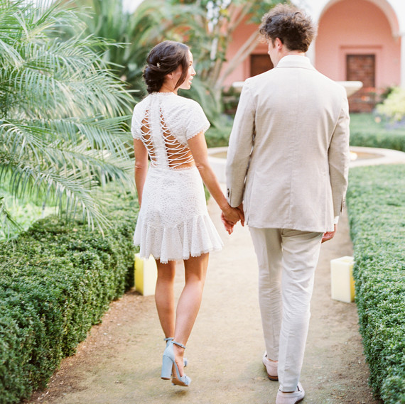 bride and groom holding hands walking down path bride and groom holding hands walking down path