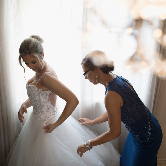 Bride Getting Dressed with the Help of Her Mother on Wedding Day Bride Getting Dressed with the Help of Her Mother on Wedding Day