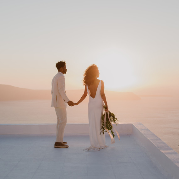 sunset wedding photos bride and groom holding hands on rooftop in greece sunset wedding photos bride and groom holding hands on rooftop in greece