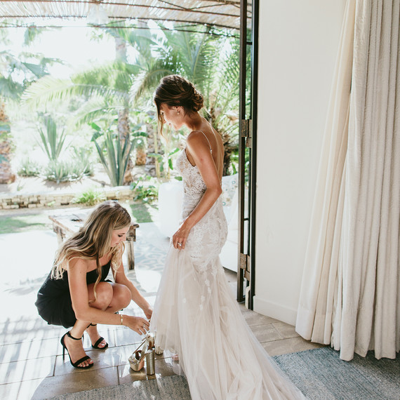 maid of honor helping bride with her shoes maid of honor helping bride with her shoes