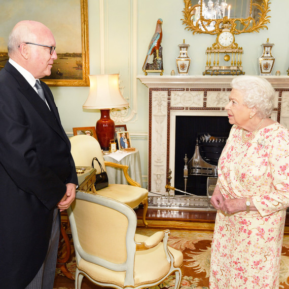 queen elizabeth ii with photo of prince harry and meghan markle in background queen elizabeth ii with photo of prince harry and meghan markle in background