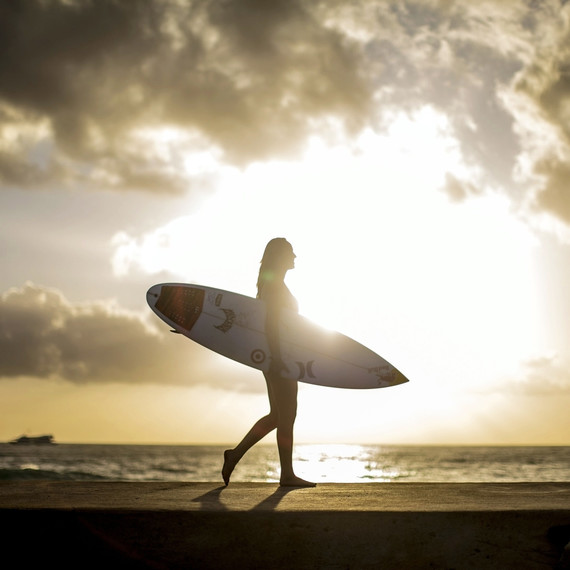 carissa moore pro surfer walking on the beach in hawaii holding her surfboard carissa moore pro surfer walking on the beach in hawaii holding her surfboard