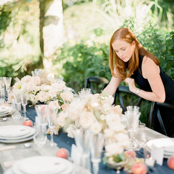 wedding planner putting finishing touches on a reception table wedding planner putting finishing touches on a reception table