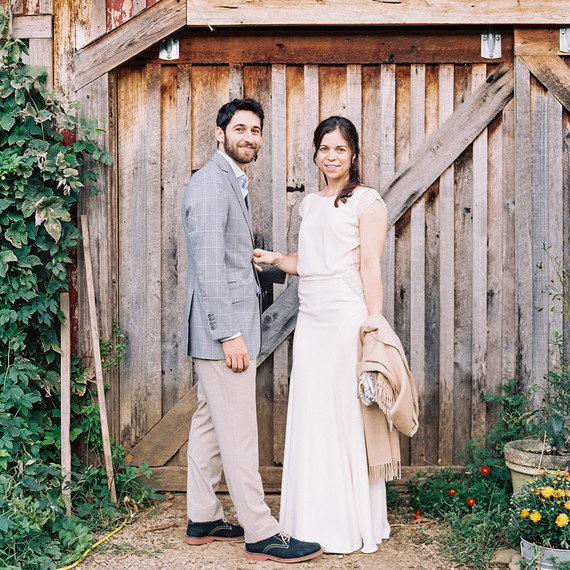 beth aaron in front of barn door with greenery beth aaron in front of barn door with greenery