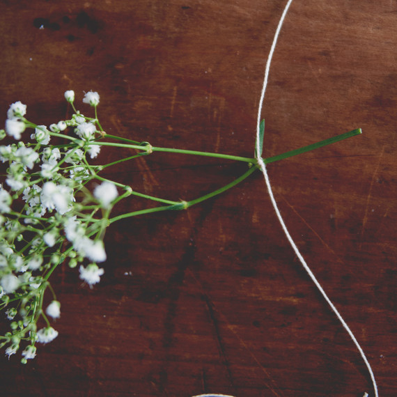 claire-thomas-bridal-shower-garden-diy-tying-string-around-flowers3-0814.jpg